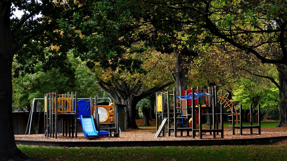 An empty children’s playground under trees